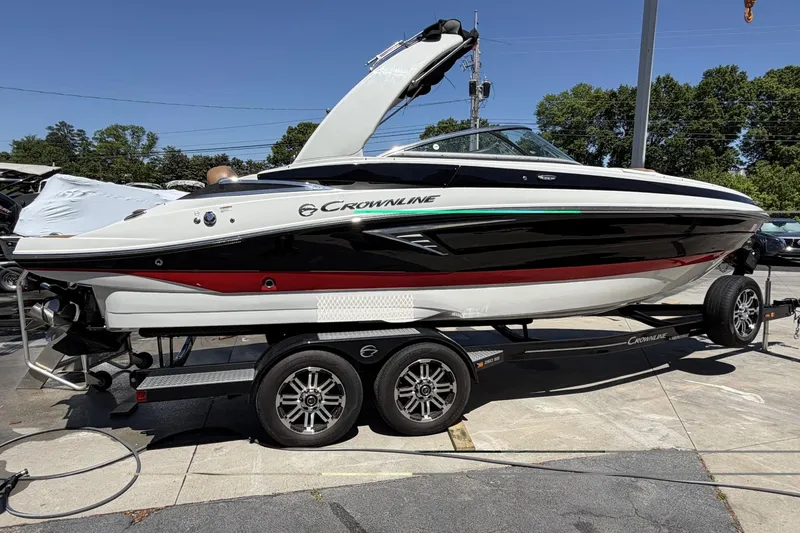 Slide: The Image of 2024 Crownline 260 SS boat on trailer, sleek design, black and white with red accents. - 2