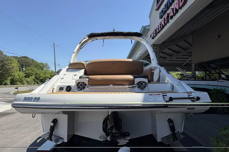 Slide: The Image of 2024 Crownline 260 SS boat, rear view, showcasing seating and speakers at a marina. - 9
