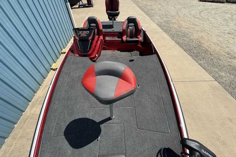 Slide: The Image of 2026 Nitro Z20 XL Pro boat with red and gray seating, parked near a blue building. - 14