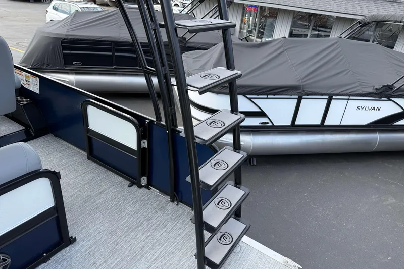 Slide: The Image of Stairs on 2025 Premier 250 Solaris Upper Deck - CL pontoon boat, docked beside covered vessel. - 21