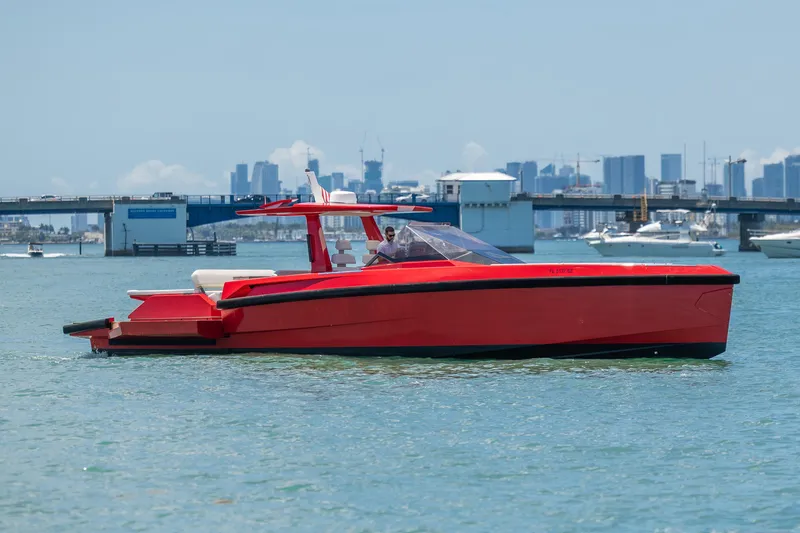 Slide: The Image of Red 2021 Wally 48 yacht cruising near a city skyline and bridge. - 2