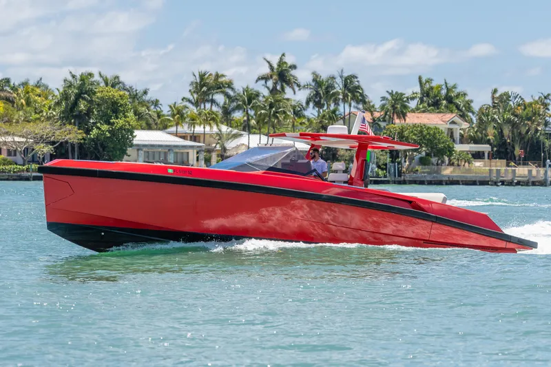 Slide: The Image of Red 2021 Wally 48 yacht cruising on a sunny day near waterfront homes. - 21