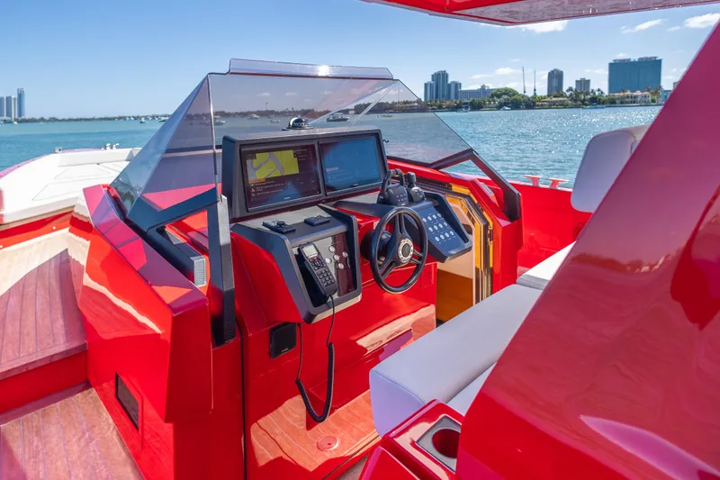 Slide: The Image of Red 2021 Wally 48 yacht cockpit with modern navigation controls, overlooking a scenic waterfront. - 30