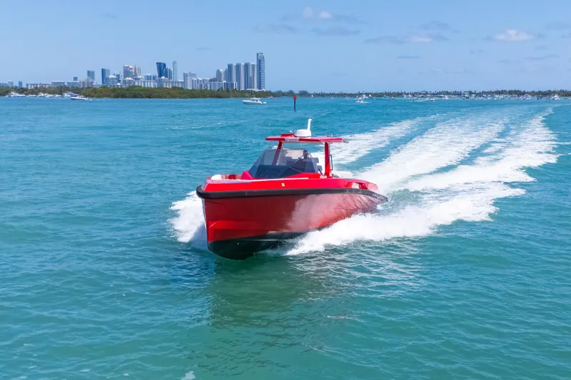 Slide: The Image of Red Wally 48 boat cruising on blue water, city skyline in background, 2021 model. - 6