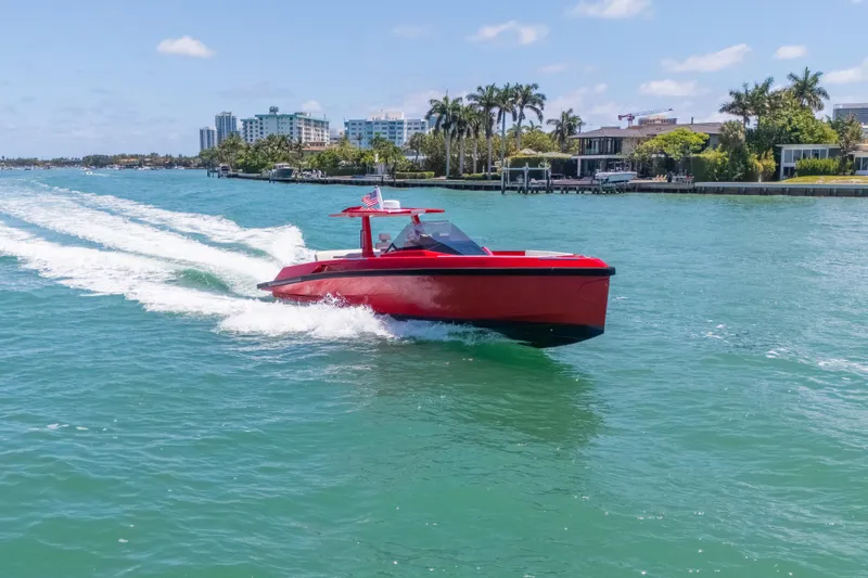 Slide: The Image of Red 2021 Wally 48 yacht cruising on turquoise water near a coastal cityscape. - 9