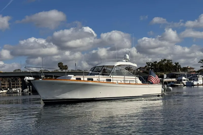 The Image of 1999 Grand Banks 38 Eastbay EX yacht on calm water, under a partly cloudy sky. - 0