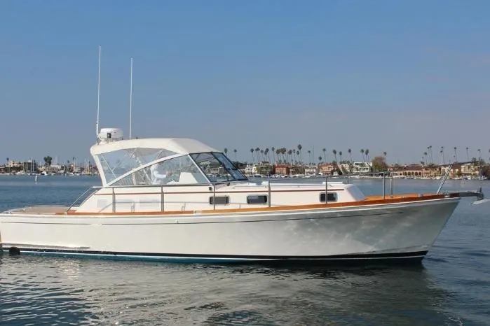 The Image of 1999 Grand Banks 38 Eastbay EX yacht on calm water, clear sky background. - 1