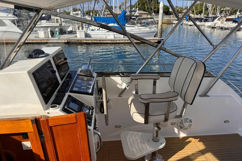 Slide: The Image of 1999 Grand Banks 38 Eastbay EX helm with controls and captain's chair at marina. - 18