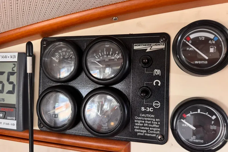 Slide: The Image of Instrument panel of a 1999 Grand Banks 38 Eastbay EX with gauges and controls. - 24