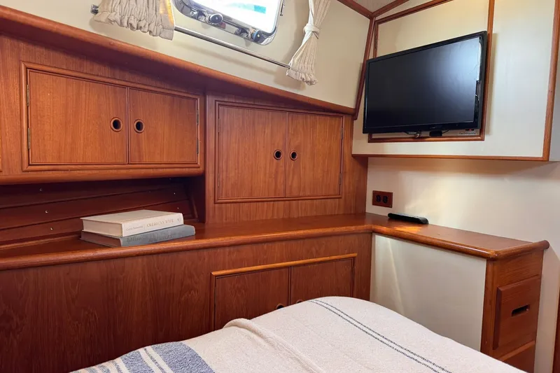Slide: The Image of Cozy cabin interior of 1999 Grand Banks 38 Eastbay EX with wood cabinetry and mounted TV. - 34