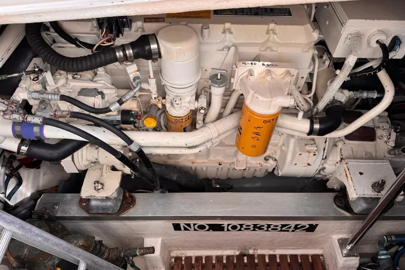 Slide: The Image of Engine compartment of a 1999 Grand Banks 38 Eastbay EX, showcasing mechanical components and hoses. - 37