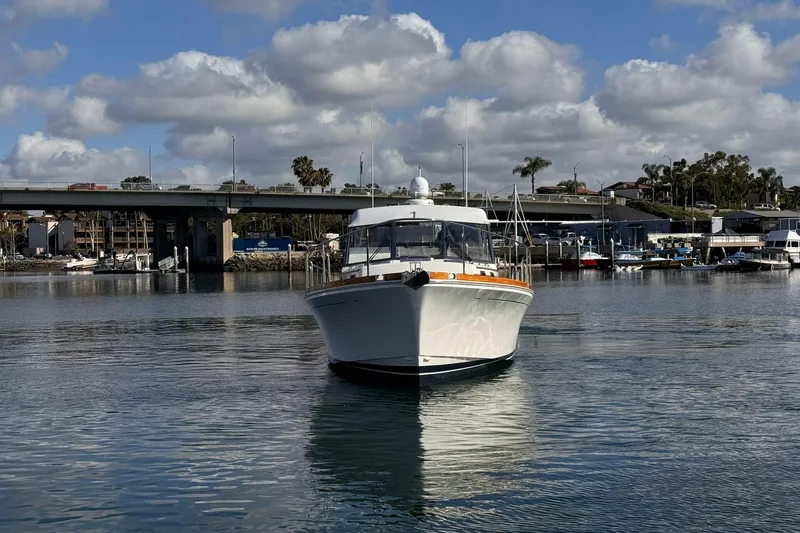 Slide: The Image of 1999 Grand Banks 38 Eastbay EX yacht on calm water near a bridge and marina. - 7