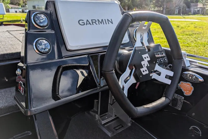 Slide: The Image of 2026 Bass Cat Cougar FTD boat dashboard with Garmin display and steering wheel. - 16