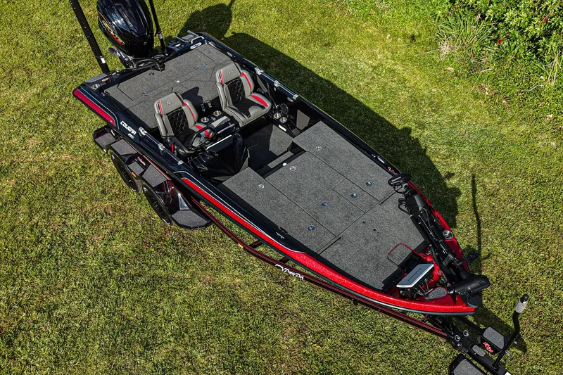 Slide: The Image of 2026 Bass Cat Cougar FTD boat on grass, showcasing sleek design and dual seating. - 2