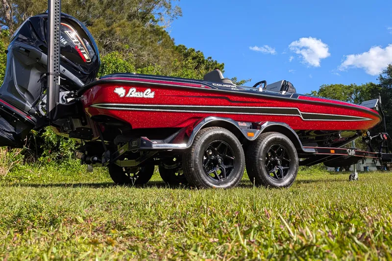 Slide: The Image of 2026 Bass Cat Cougar FTD boat on trailer, parked on grass under blue sky. - 5