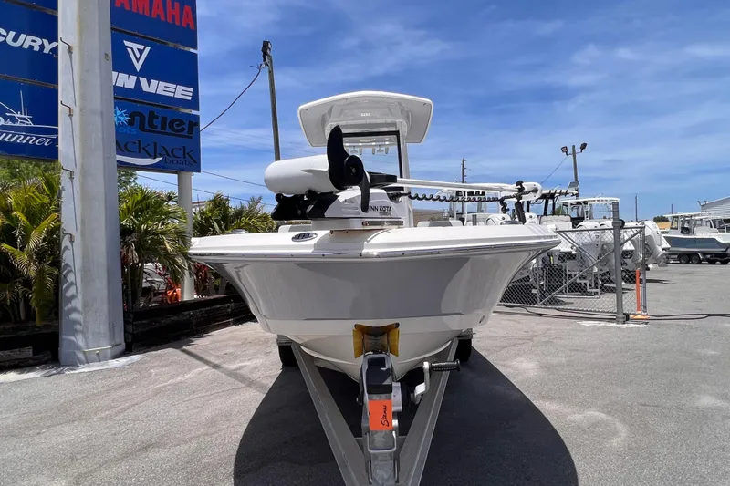 Slide: The Image of 2022 Robalo 246 Cayman boat on trailer at dealership under clear blue sky. - 1