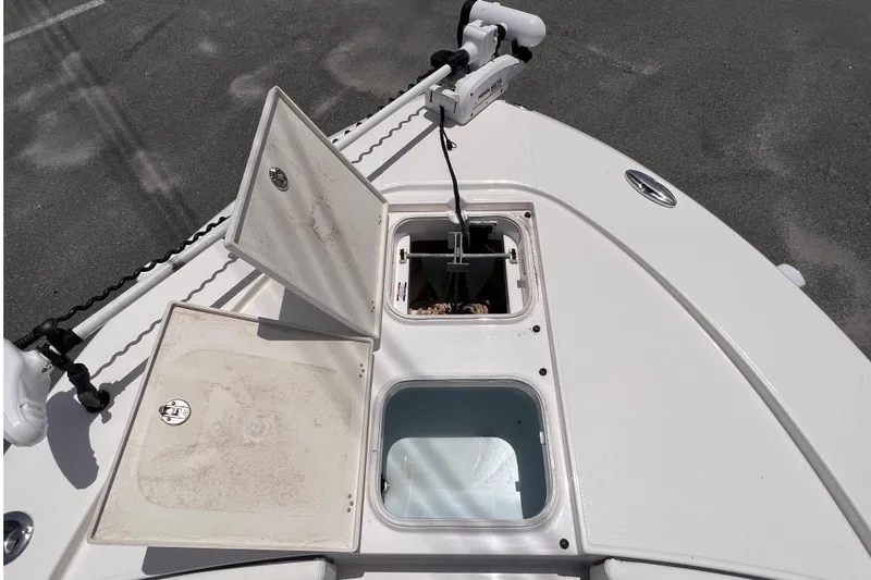 Slide: The Image of 2022 Robalo 246 Cayman boat deck with open storage compartments and trolling motor. - 7