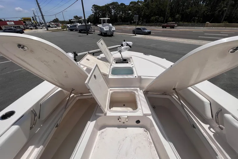 Slide: The Image of 2022 Robalo 246 Cayman boat with open storage compartments and seating area. - 8