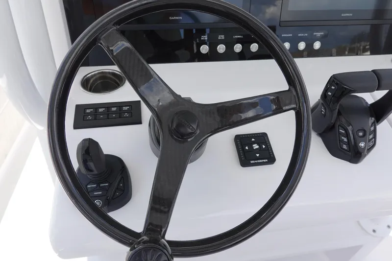 Slide: The Image of Steering wheel and controls of 2026 Jupiter 32 FS boat, featuring advanced navigation technology. - 11