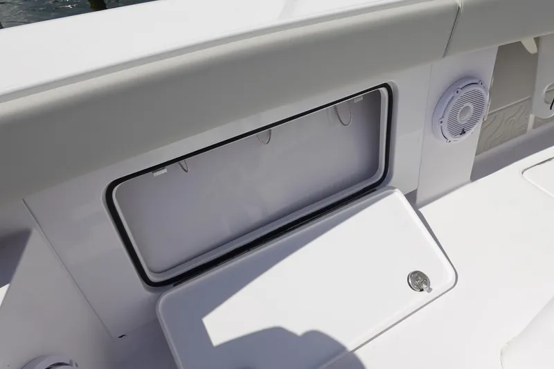 Slide: The Image of Open storage compartment on 2026 Jupiter 32 FS boat deck with speaker. - 6