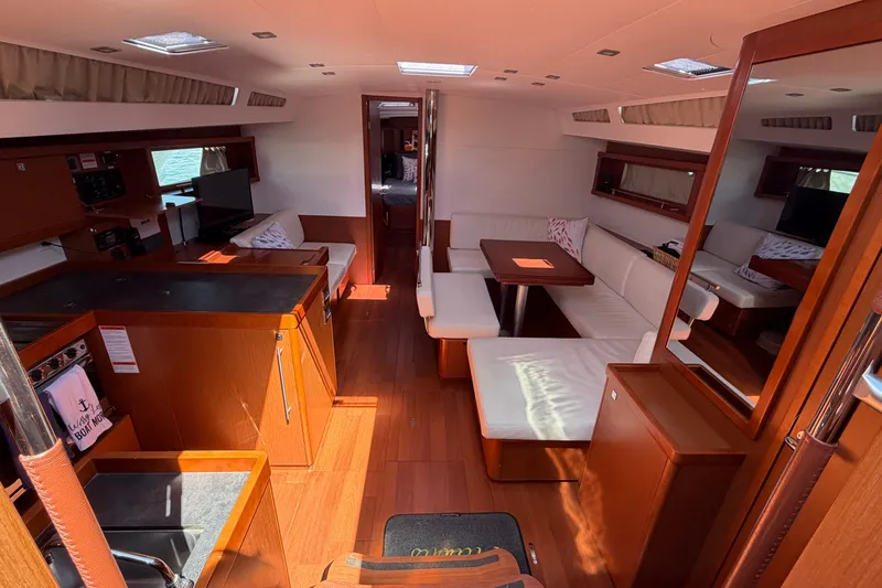 Slide: The Image of Interior of 2016 Beneteau Oceanis 48 yacht with elegant wood finish and spacious seating. - 2