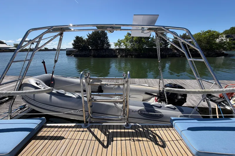 Slide: The Image of Beneteau Oceanis 48 (2016) yacht with dinghy docked by a serene waterfront. - 21