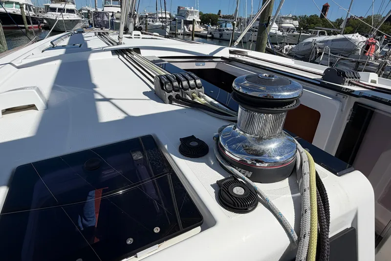 Slide: The Image of 2016 Beneteau Oceanis 48 yacht deck with winch and ropes in marina setting. - 22