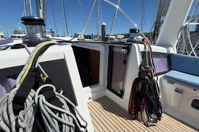 Slide: The Image of 2016 Beneteau Oceanis 48 sailboat deck with ropes and winches in a marina setting. - 23