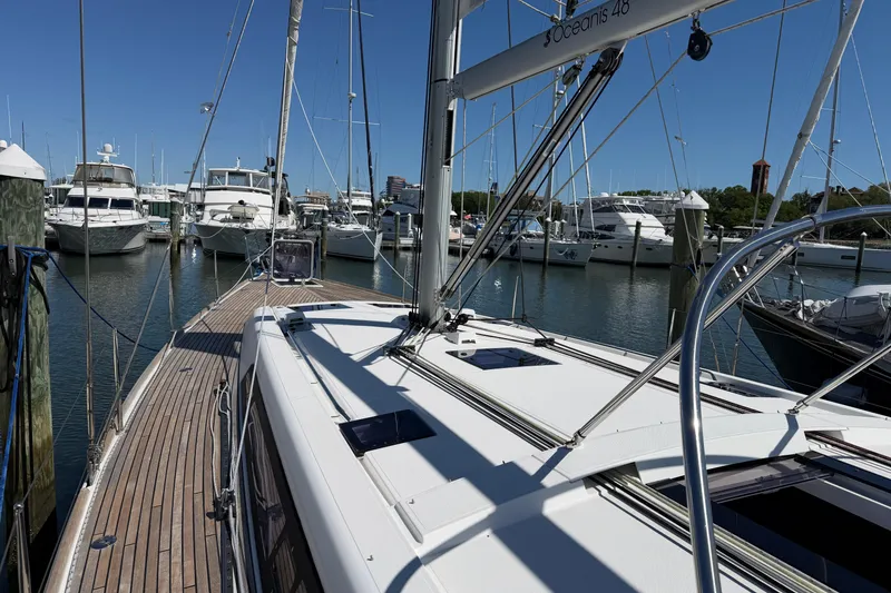 Slide: The Image of 2016 Beneteau Oceanis 48 yacht docked in a marina under clear blue skies. - 3