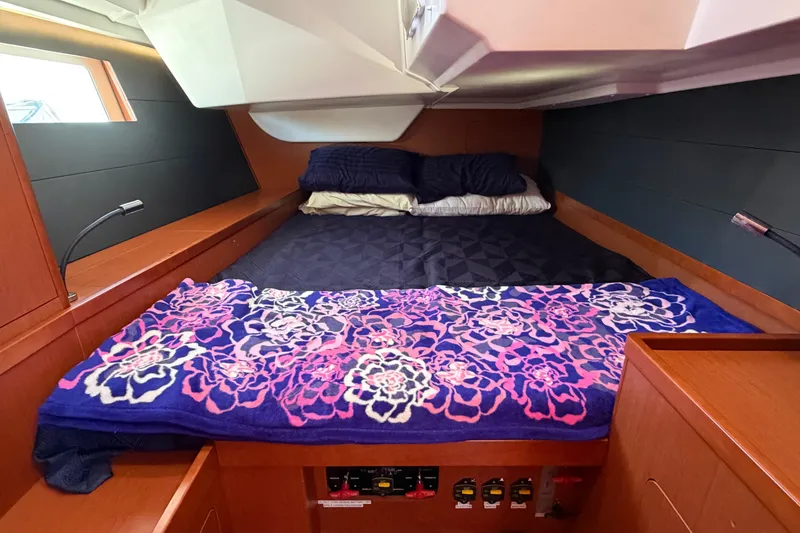 Slide: The Image of Cozy cabin interior of 2016 Beneteau Oceanis 48 with floral blanket and wooden accents. - 30