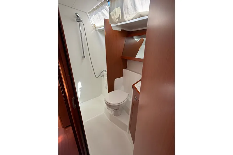 Slide: The Image of 2016 Beneteau Oceanis 48 yacht bathroom with shower, toilet, and wooden cabinetry. - 33