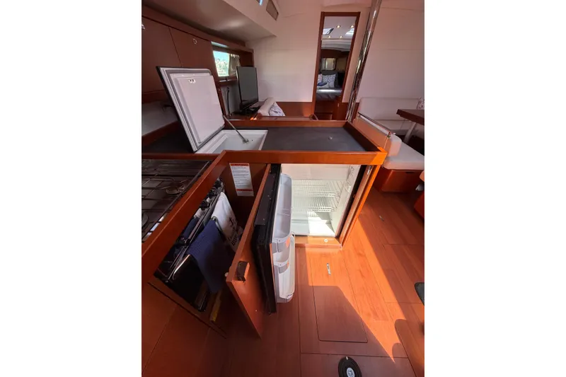 Slide: The Image of Interior of 2016 Beneteau Oceanis 48 yacht, featuring a modern kitchen with open fridge. - 36
