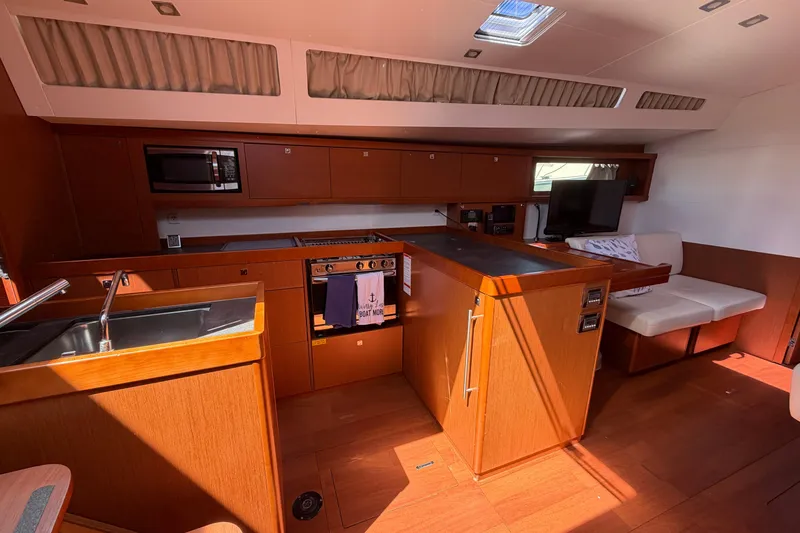 Slide: The Image of Interior of 2016 Beneteau Oceanis 48 yacht with modern kitchen and seating area. - 38