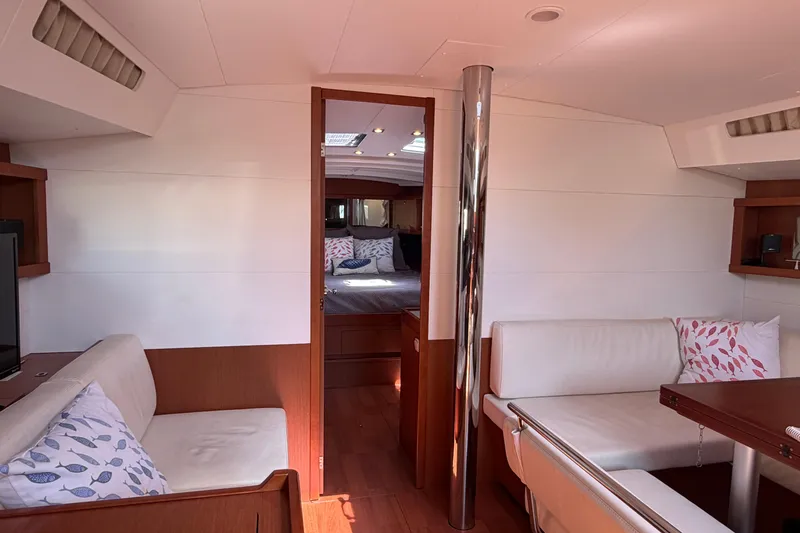 Slide: The Image of Interior of 2016 Beneteau Oceanis 48 yacht, featuring cozy seating and elegant wood finishes. - 41