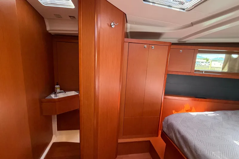 Slide: The Image of Interior of 2016 Beneteau Oceanis 48 yacht with wooden cabinetry and cozy sleeping area. - 44