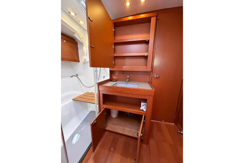 Slide: The Image of Interior of 2016 Beneteau Oceanis 48 yacht bathroom with wooden cabinetry and sink. - 48