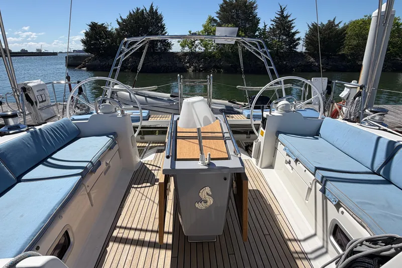 Slide: The Image of 2016 Beneteau Oceanis 48 sailboat cockpit with dual steering wheels and blue seating. - 50