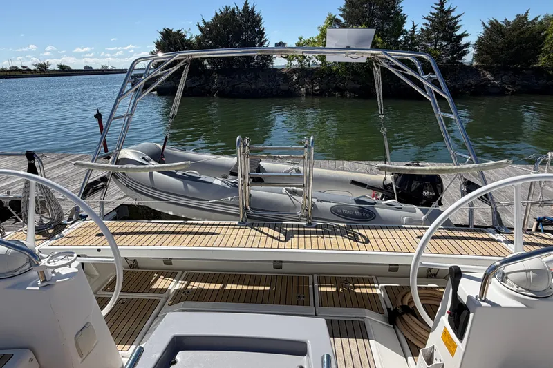 Slide: The Image of 2016 Beneteau Oceanis 48 yacht with dinghy, docked by a serene waterfront. - 51