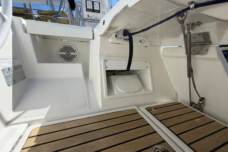 Slide: The Image of Cockpit of 2016 Beneteau Oceanis 48 sailboat with teak flooring and storage compartments. - 53