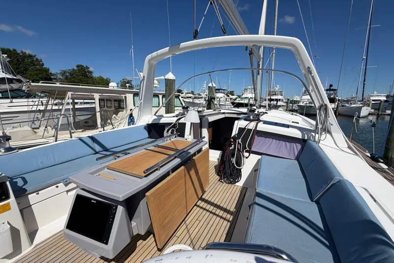 Slide: The Image of 2016 Beneteau Oceanis 48 yacht cockpit with blue seating, docked at marina under clear sky. - 55