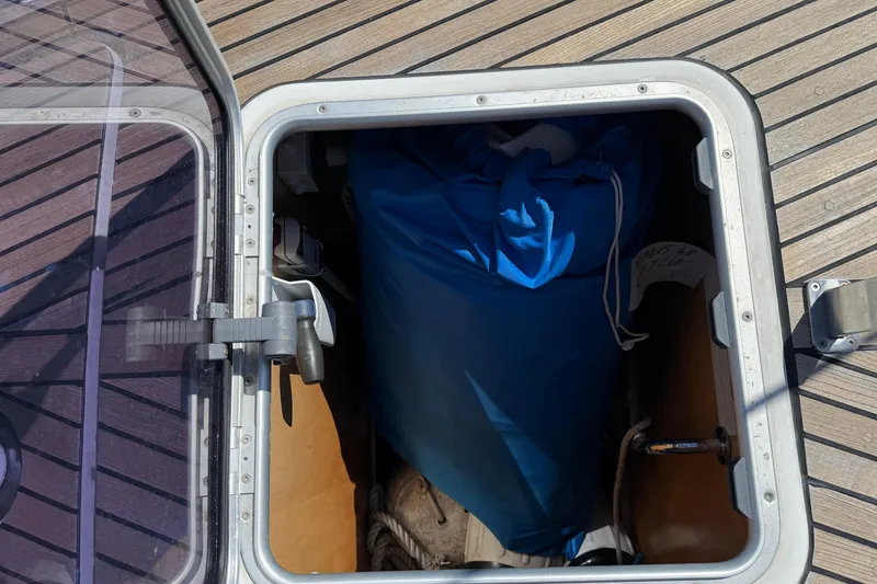 Slide: The Image of Storage compartment on 2016 Beneteau Oceanis 48 sailboat deck, containing blue bag. - 7