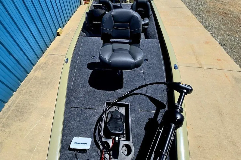 Slide: The Image of 2026 Tracker Pro Team 190 boat interior with seating and equipment, parked on concrete. - 19