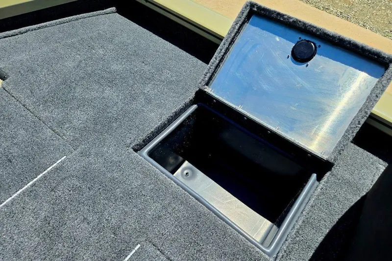 Slide: The Image of Open storage compartment on 2026 Tracker Pro Team 190 boat with carpeted deck. - 46