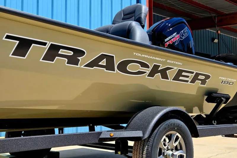 Slide: The Image of 2026 Tracker Pro Team 190 boat with Mercury Pro XS engine, parked near blue building. - 7