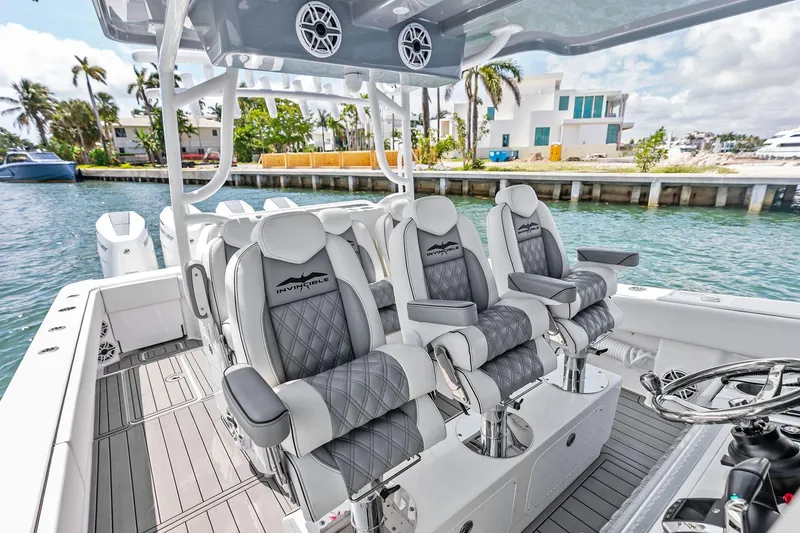 Slide: The Image of 2024 Invincible 43 Open Fisherman boat interior with luxury seating and waterfront view. - 13