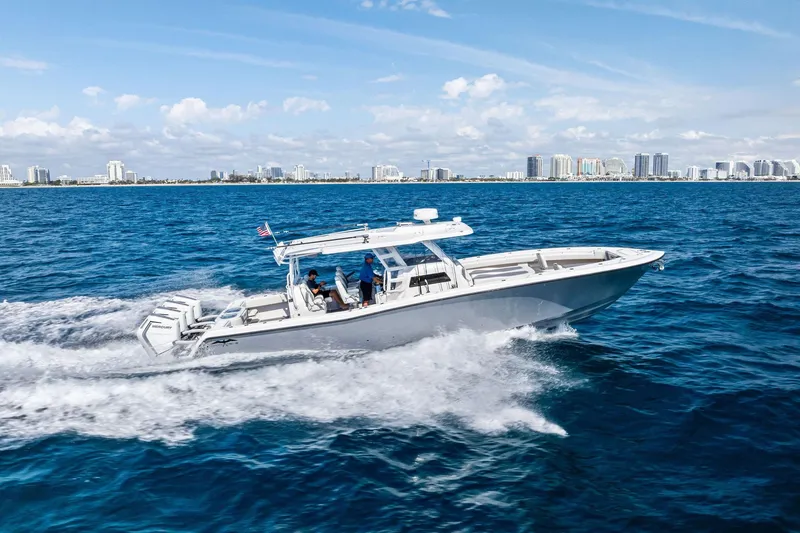 Slide: The Image of 2024 Invincible 43 Open Fisherman cruising on ocean near city skyline. - 4