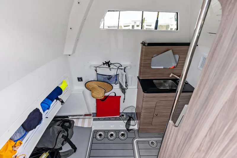 Slide: The Image of 2024 Invincible 43 Open Fisherman cabin interior with storage, sink, and fishing gear. - 41