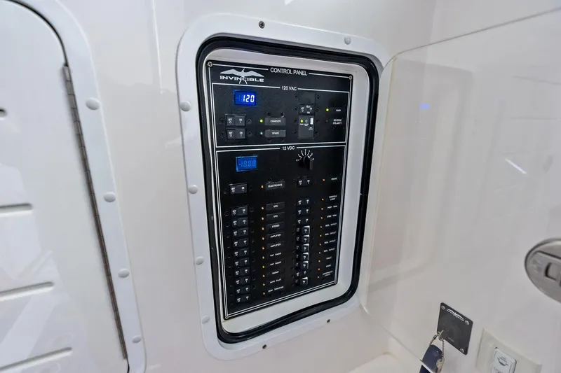Slide: The Image of 2024 Invincible 43 Open Fisherman control panel with digital displays and switches. - 43