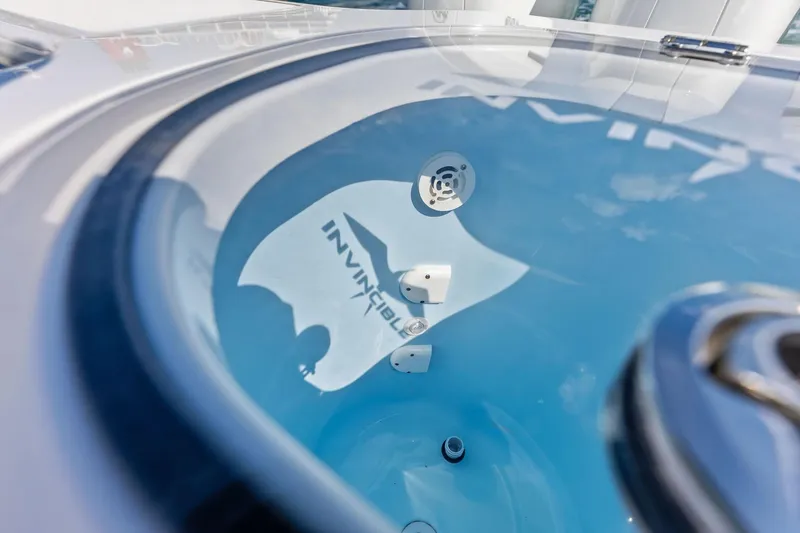 Slide: The Image of 2024 Invincible 43 Open Fisherman boat interior with logo reflection on glass surface. - 48