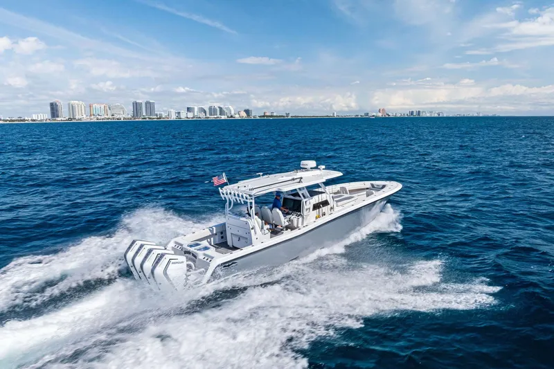 Slide: The Image of 2024 Invincible 43 Open Fisherman cruising on ocean near city skyline. - 5